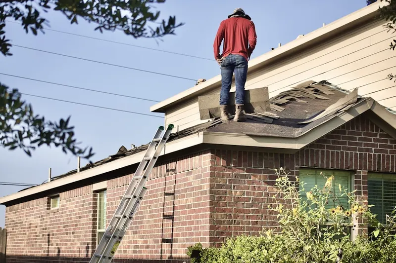 Professional roofer working on a residential roof in Vehlin